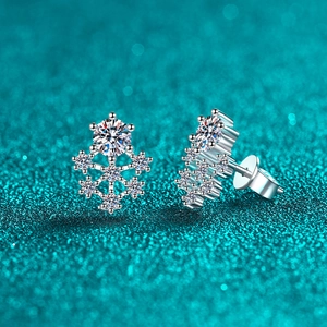 Elegant silver snowflake moissanite stud earrings with sparkling stones on blue background
