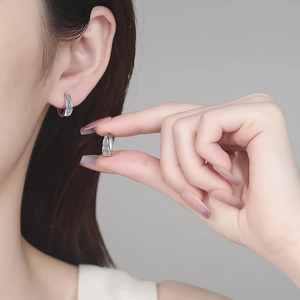 Elegant S925 sterling silver U-shaped moissanite hoop earrings shown on ear and hand