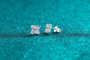 Macro shot of silver stud earrings with rectangular moissanite stones and pave detail