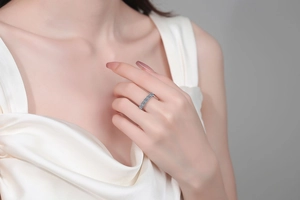 Close-up of elegant S925 silver band ring with blue moissanite stones on a model
