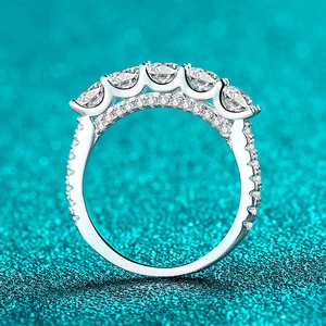 S925 sterling silver moissanite row ring with five round brilliant cut stones on teal background