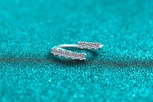 Macro shot of S925 sterling silver ring featuring double-row moissanite stones on blue glitter