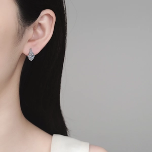 Elegant 925 sterling silver moissanite snowflake stud earrings worn by a female model