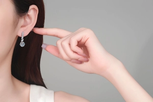 Gros plan d'élégantes boucles d'oreilles pendantes en argent S925 et moissanite sur un mannequin