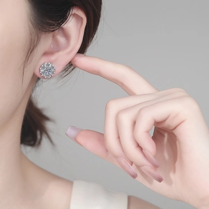 Elegant S925 sterling silver sunflower moissanite stud earrings on model ear