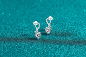 Macro shot of S925 sterling silver heart moissanite earrings with sparkling knot details