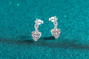 Detailed view of S925 silver heart-shaped moissanite earrings with sparkling pavé accents