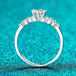 Exquisite S925 sterling silver moissanite ring featuring a six-prong setting on green background