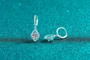 Macro view of sterling silver water drop earrings with round moissanite and pave stones