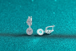 Macro shot of S925 sterling silver moissanite earrings with halo setting on a blue background