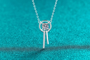 Macro detail of S925 silver moissanite pendant with tassel drop on blue background