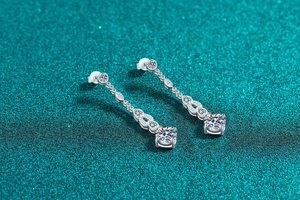 Macro detail of S925 sterling silver tassel earrings with round moissanite drop pendants