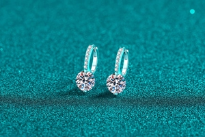 Macro de boucles d'oreilles moissanite en argent S925 sur un fond bleu scintillant