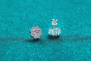 Macro shot of silver sunflower stud earrings with central moissanite and petal stones