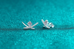 Macro view of crossover geometric S925 silver stud earrings with moissanite accents