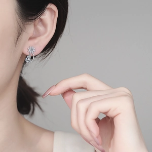 Eleganti orecchini a fiore in argento S925 con moissanite indossati da una modella