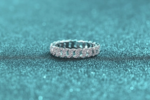 Gros plan détaillé d'une bague maille cubaine en argent sertie de moissanite sur fond scintillant
