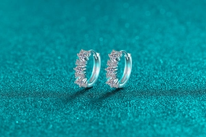 Dettaglio di orecchini a cerchio in argento S925 con cinque pietre di moissanite lucenti
