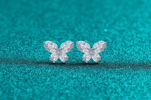 Macro detail of S925 sterling silver butterfly stud earrings with sparkling moissanite stones