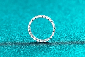 Détail d'une bague en argent 925 avec bords ondulés et sertissage pavé de moissanite