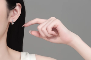 Detailed close-up of S925 sterling silver moissanite wave earrings on model's ear