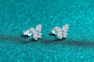 Macro detail of silver butterfly earrings with sparkling moissanite stones and marquise cut