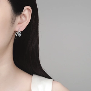 Elegant S925 silver bow stud earrings with sparkling moissanite on female model