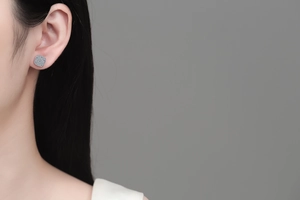 Macro detail of square micro-pave moissanite stud earrings worn on a female model ear