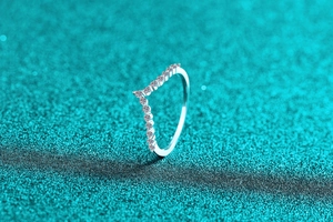 Close-up of a delicate V-shaped S925 sterling silver ring featuring a Moissanite pavé band