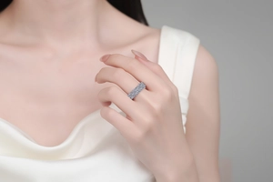 Detail eines S925 Sterlingsilberrings mit blauen und weißen Moissaniten am Finger der Frau