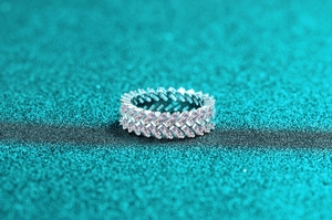 Macro detail of S925 silver ring featuring baguette-cut pink stones in a woven setting
