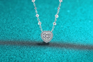 Gros plan d'un collier en argent avec pendentif cœur en moissanite et détails pavés
