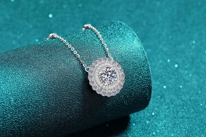 Detailed view of sunflower Moissanite pendant with sparkling diamond halo on green background