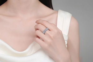 S925 sterling silver ring with blue and white moissanite worn by a model on white satin