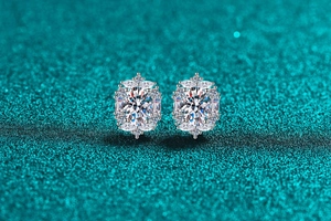 Macro shot of S925 sterling silver moissanite stud earrings on a blue glitter surface