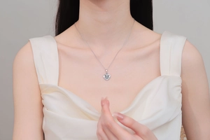 Macro detail of S925 silver heart necklace with blue gemstone on a female model