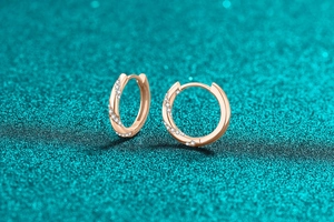 Macro shot of rose gold hoop earrings with twisted design and pave-set crystals
