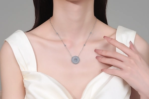 Detailed close-up of a sunflower moissanite necklace with layered gems on a model