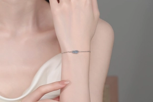 Close-up of elegant S925 sterling silver bracelet with blue and white moissanite on wrist