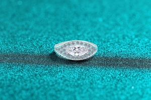 Macro detail of marquise cut moissanite ring with halo setting and pave side stones