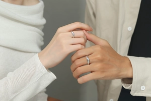 Close-up of minimalist S925 sterling silver couple rings featuring a small moissanite stone