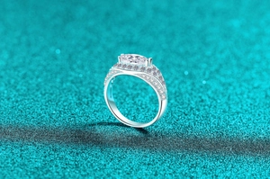 Macro detail of marquise-cut moissanite ring with pavé diamonds in silver setting