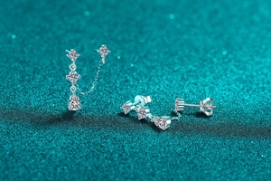 Detail of silver moissanite tassel earrings with sparkling teardrop stones on green background