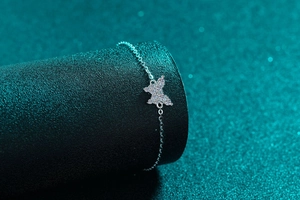Detailaufnahme eines S925 Silber-Armbands mit funkelnder Moissanit-Schmetterling-Verzierung