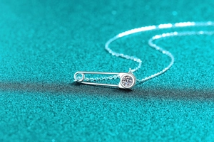 Macro du pendentif épingle de sûreté en argent avec moissanite sur une chaîne fine