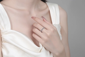 Close-up of S925 sterling silver moissanite eternity ring worn by model on silk background