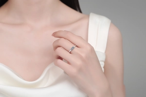 Gros plan d'une bague en argent S925 avec trois pierres moissanites bleu clair au doigt