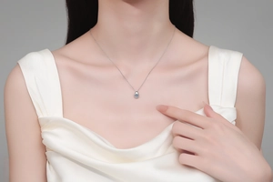 Close-up of elegant S925 sterling silver teardrop moissanite pendant on female neck