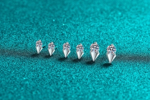 Macro shot of six S925 sterling silver moissanite studs on blue glitter background