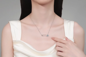 Détail du collier épingle à nourrice en argent S925 avec moissanite porté par un modèle